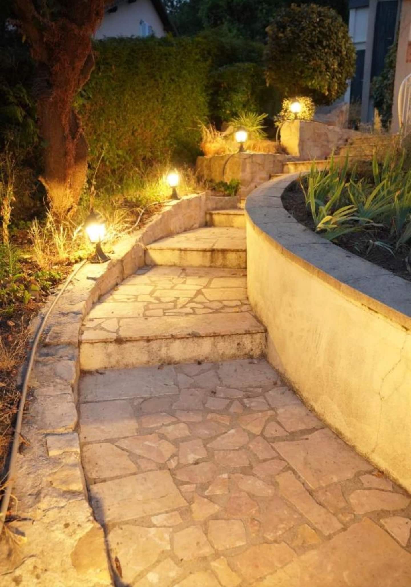 L'allée pavée du domaine éclairée le soir